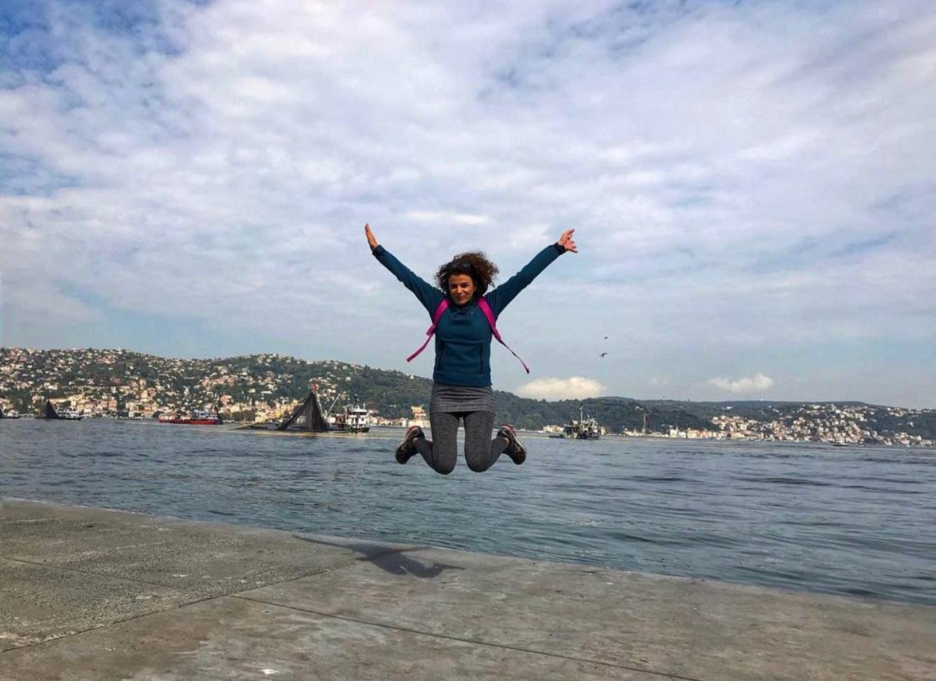 Neslihan Albayrak Boğaz kıyısında bulutların altında neşeyle zıplarken